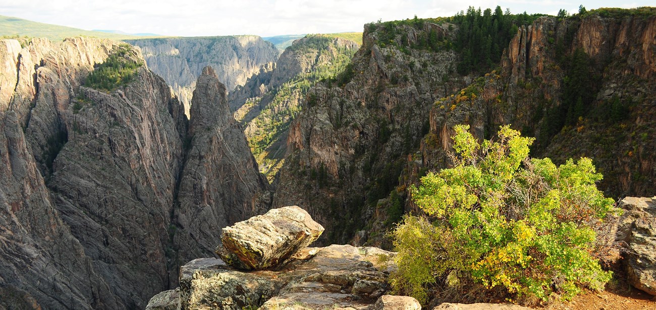 A view into a steep canyon with cross fissures in the rock