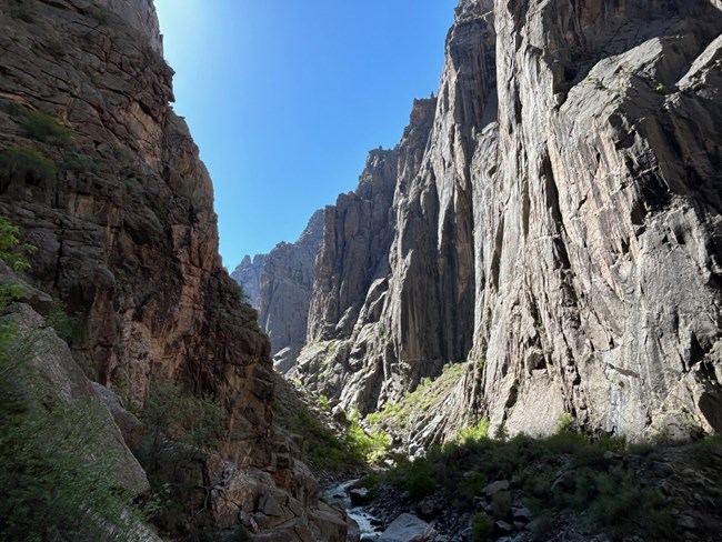 View of steep, dark canyon wall from down within