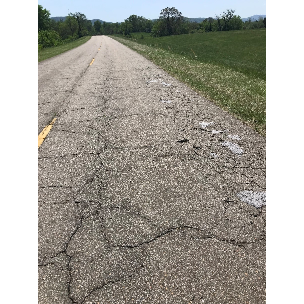 cracked roads Cracked roads with surrounding grass.