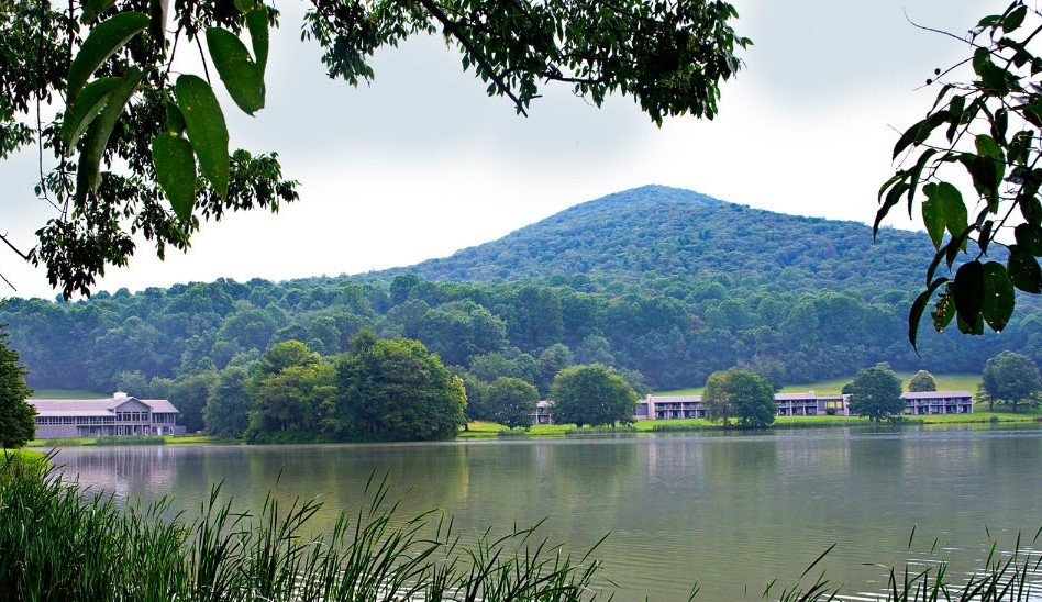 peaks for prospectus announcement A lake with buildings surrounding and a mountain in the background.