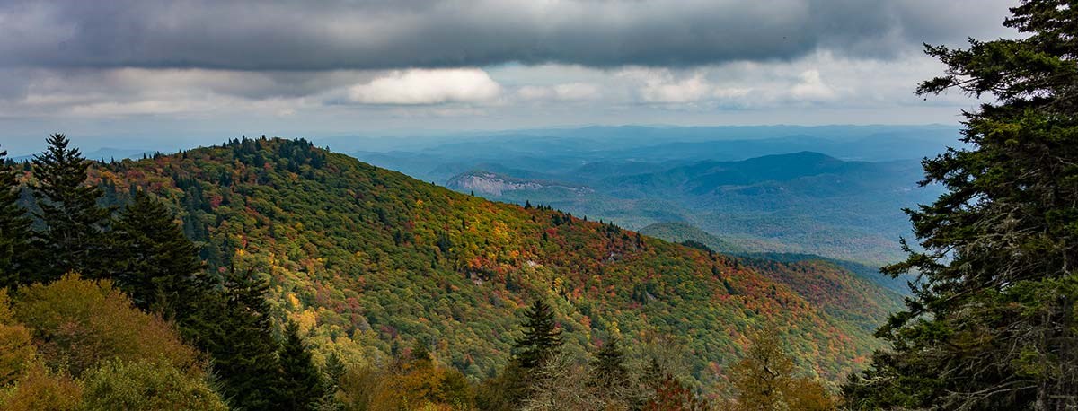 The view from the parkway of a large rock dome (Looking Glass Rock) in Pisgah National Forest. The forest stretches to the horizon.