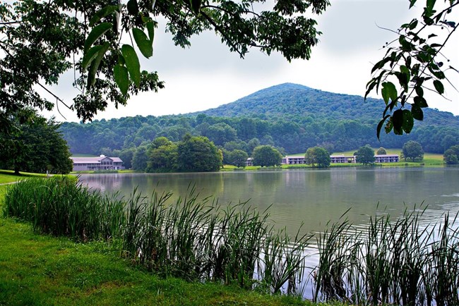 A sharply pointed mountain standing in the distance behind a small lake.