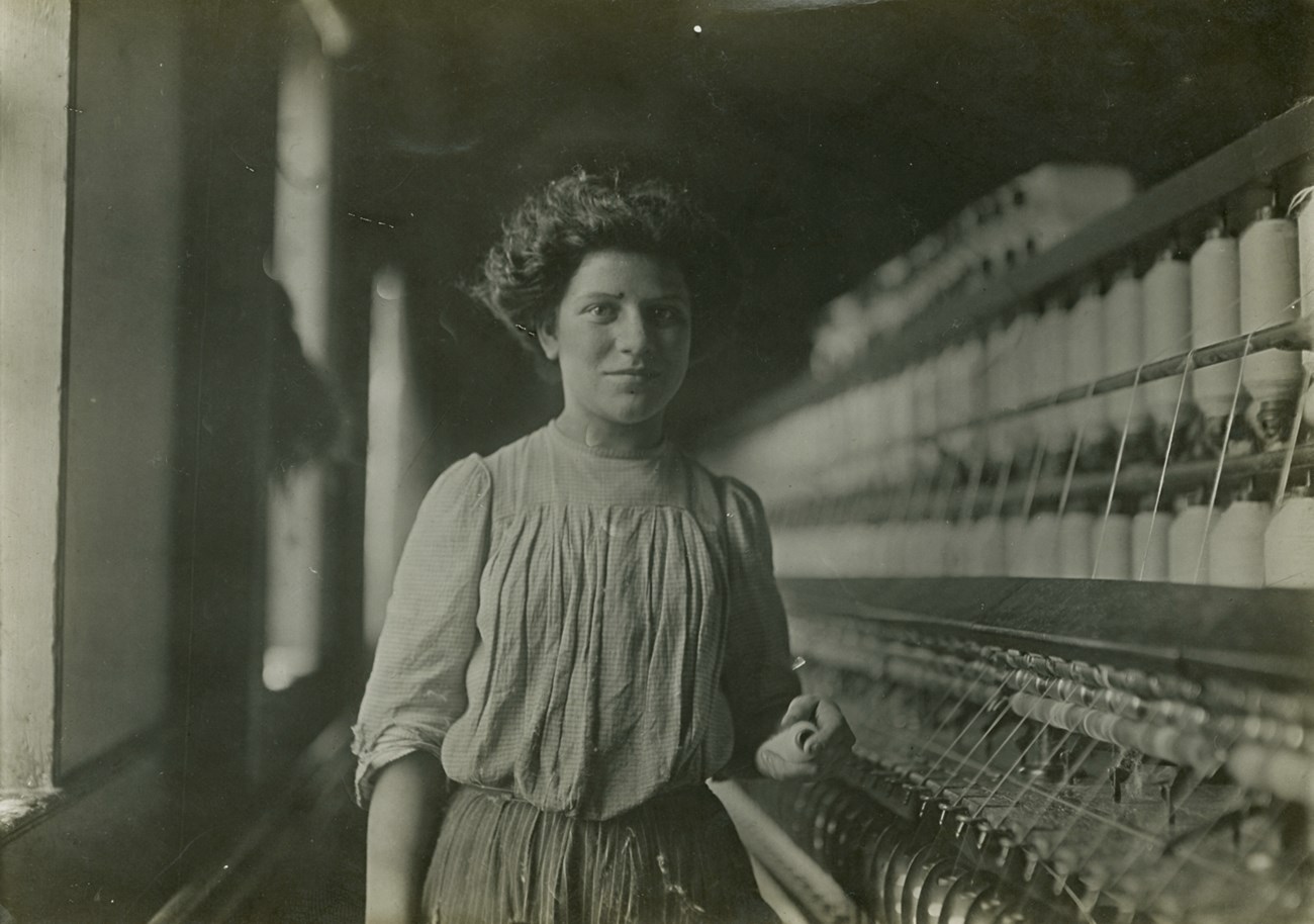Young child labor in front of machinery in mill