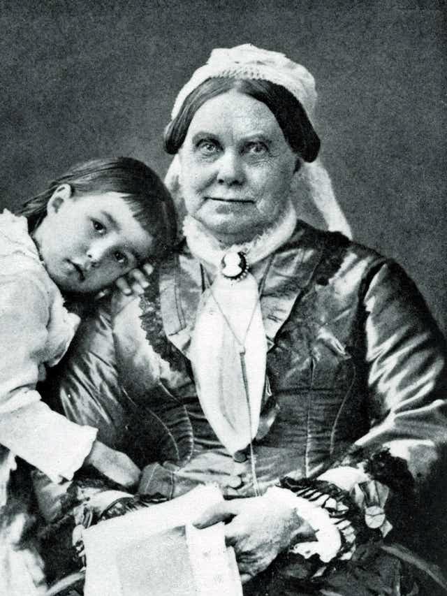 Old women seated with young girl leaning up against her