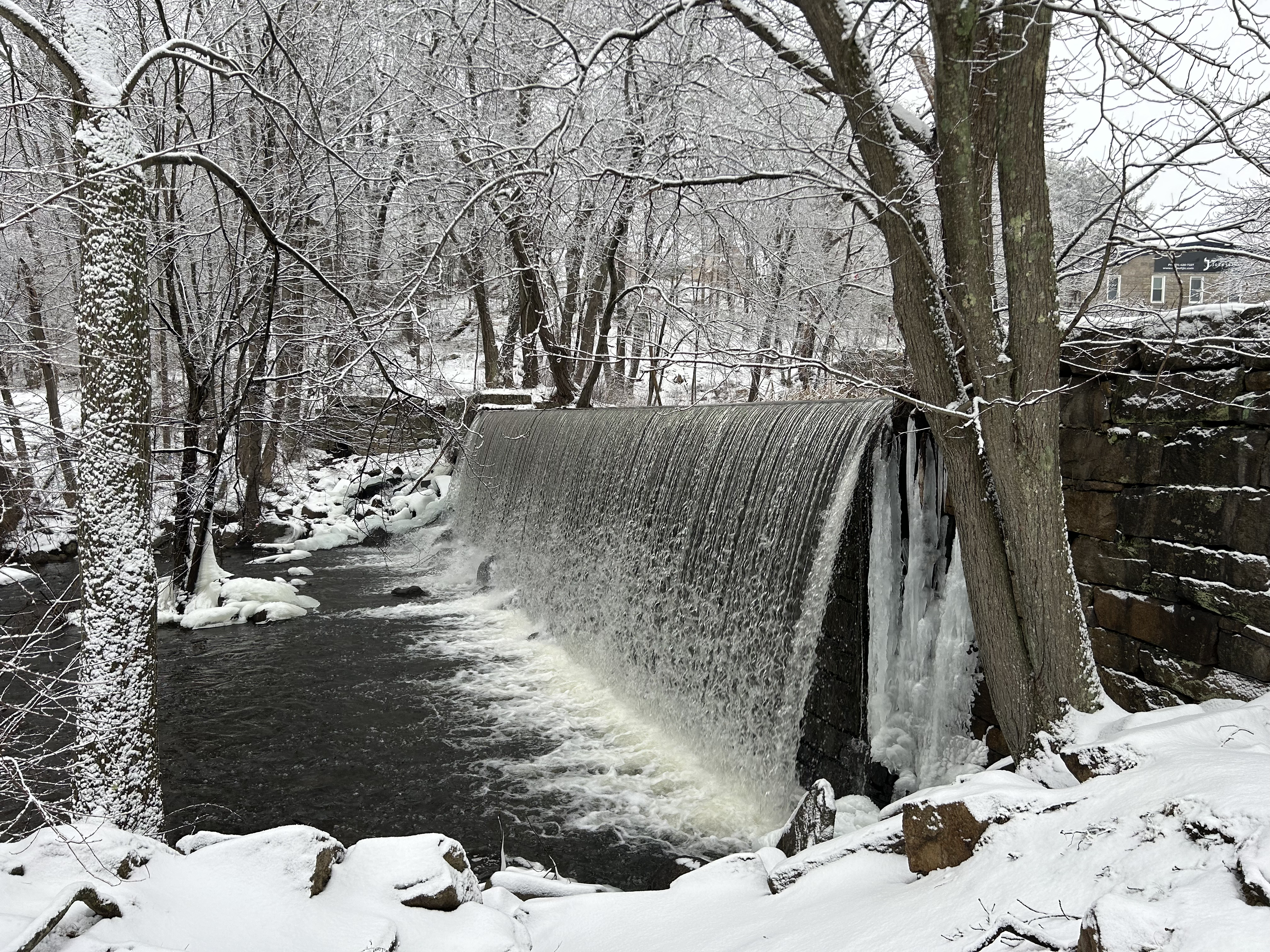 Falling water surrounded by snow and trees