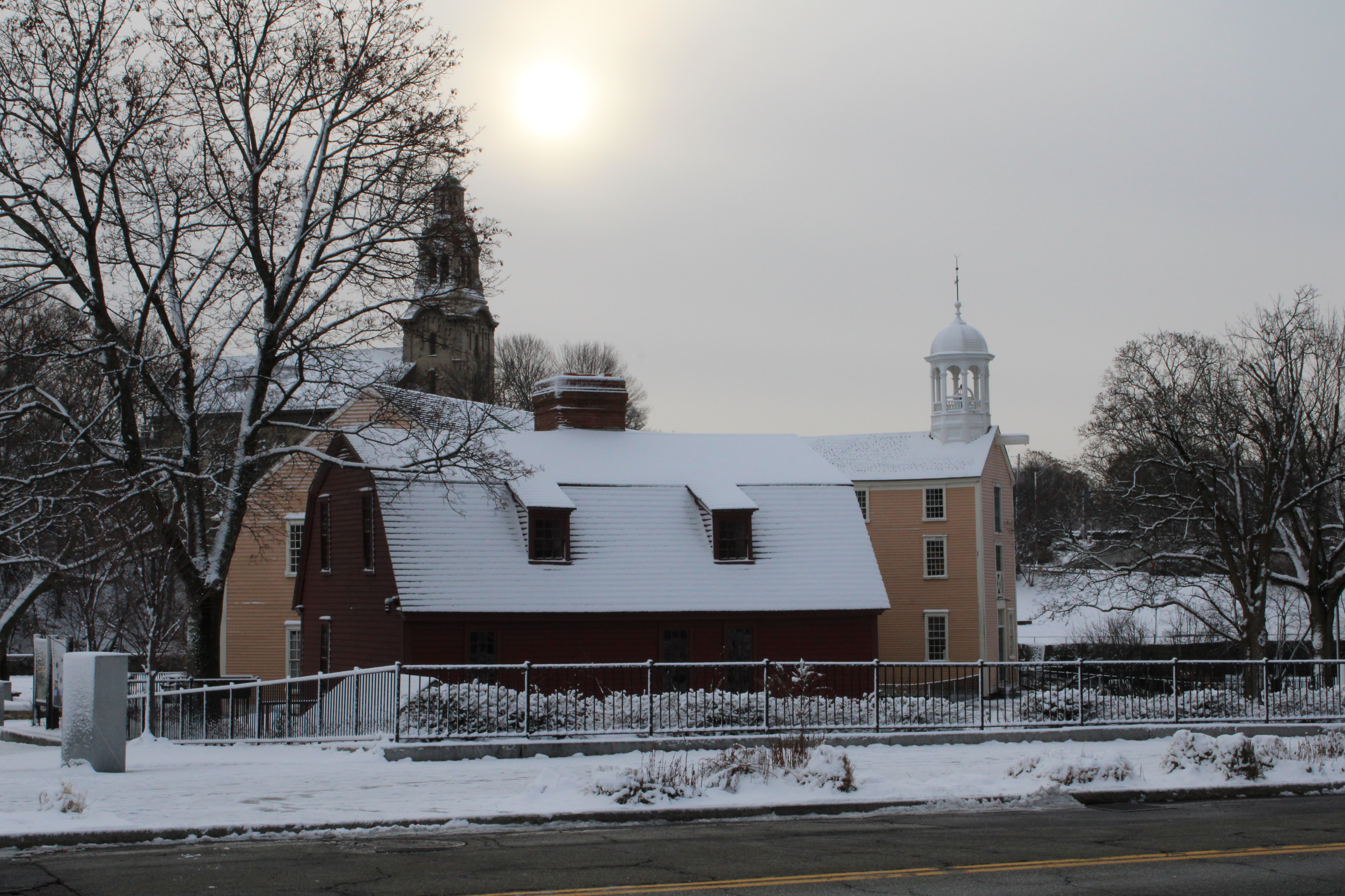 Yellow mill and red colonial home in the snow