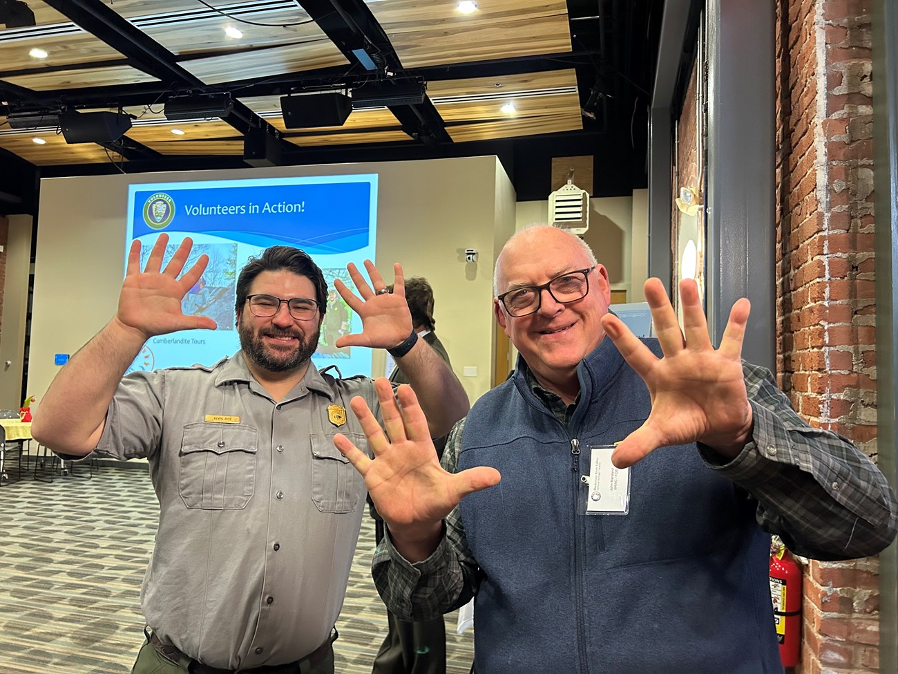 Two men stand (one in Ranger uniform) holding up ten fingers