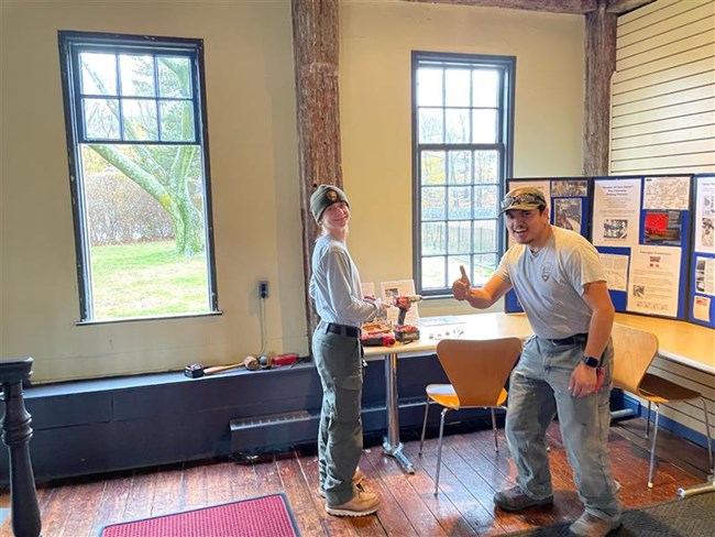Two NPS workers stand in front of window