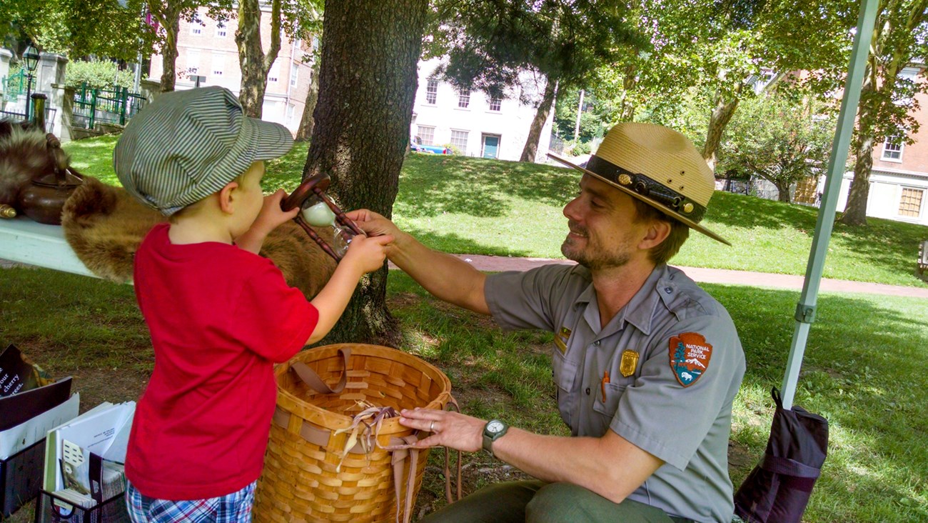 lt= Park ranger interacting with a young visitor