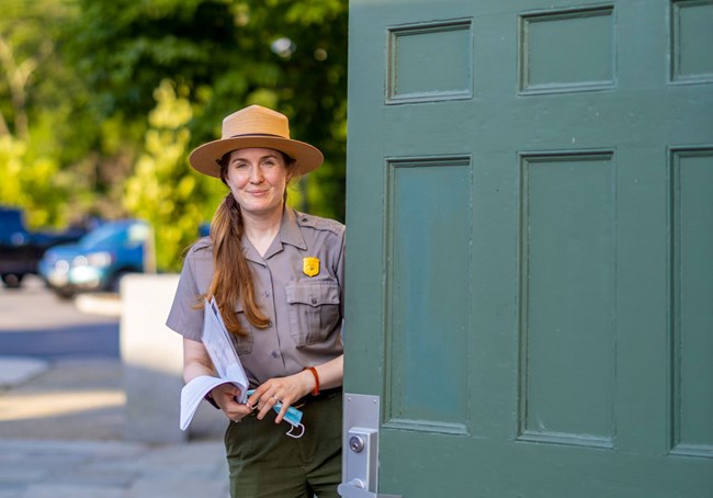 Park ranger standing at the entrance of Old Slater Mill