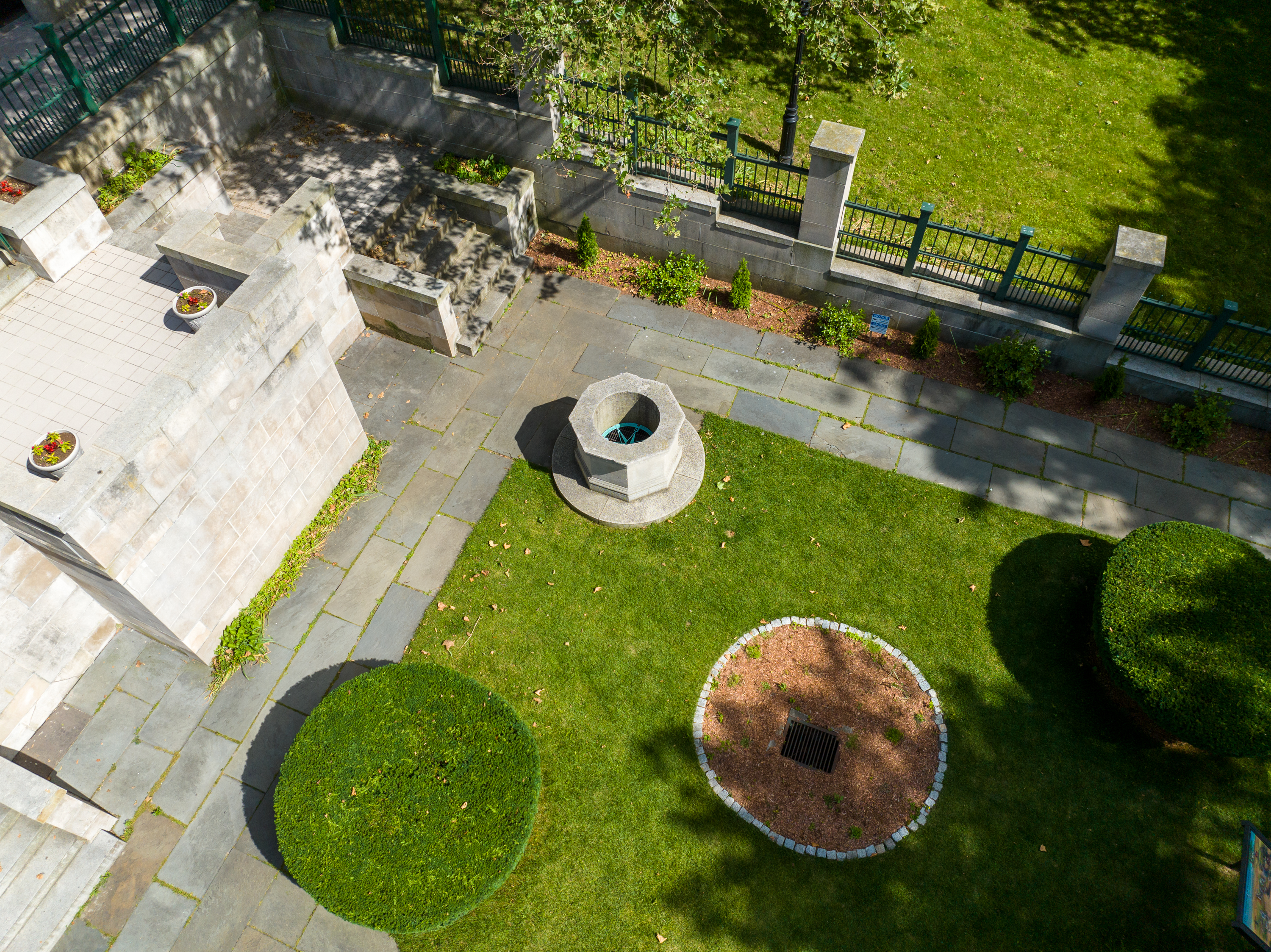 The Hahn Memorial Wellspring_ Aerial picture of the Hahn Memorial. Green grass is surrounded by stone paths and a circular stone well