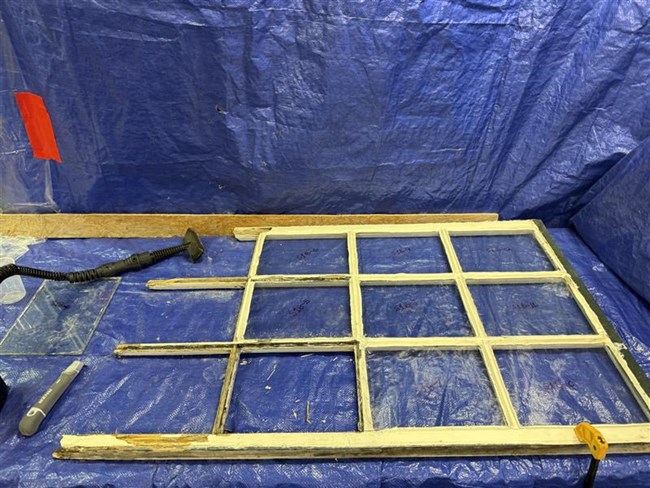 Window Repair Window frame sits on blue tarps