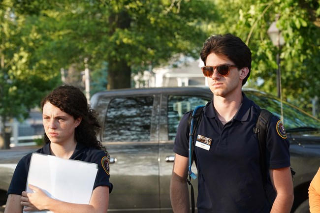 interns at walkabout Young man and young woman stand next to each other listening to presenter