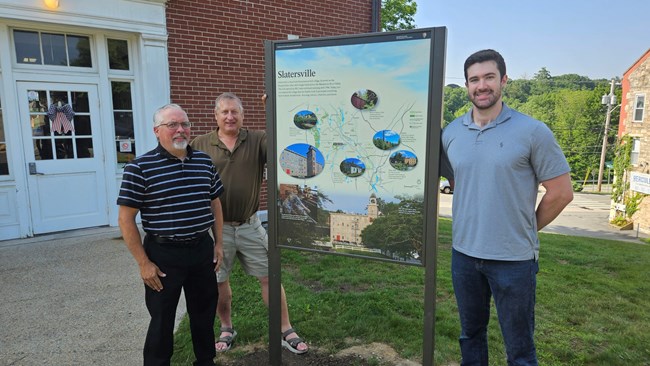 North Smithfield wayside Three people stand next to a newly installed sign