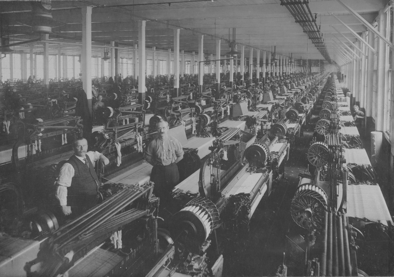 Weave room with looms and workers