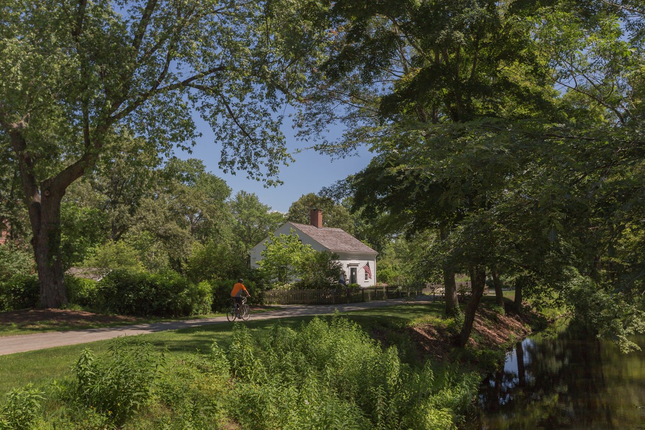 Canal in the foreground with unpaved bike path and white structure in background