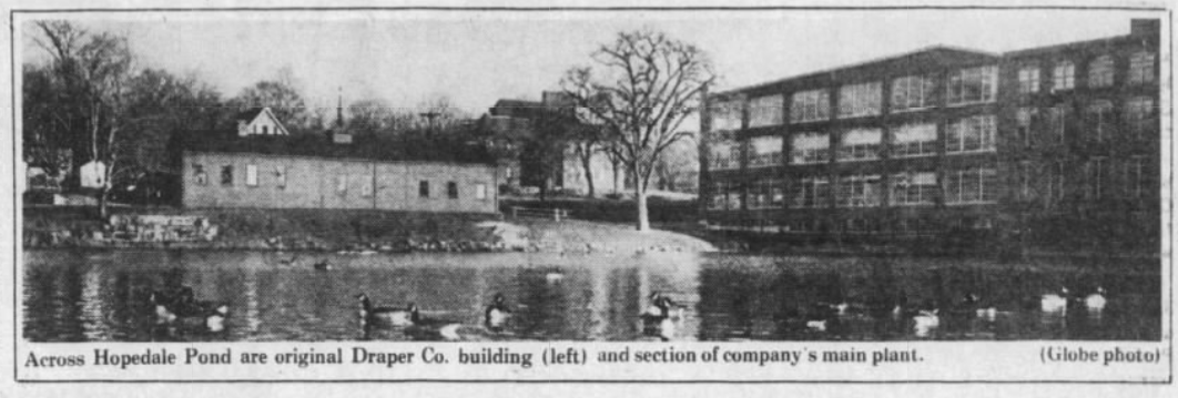 Image of pond in foreground with ducks and small structure to the left and large mill structure to the right