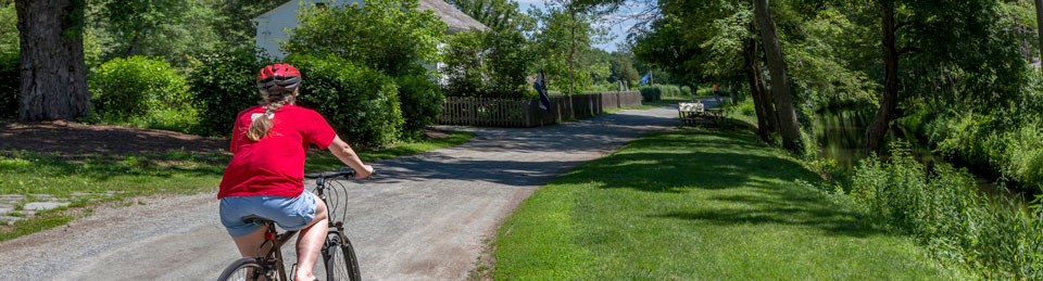 Young woman riding a bike down a dirt path Young woman riding a bike down a dirt path
