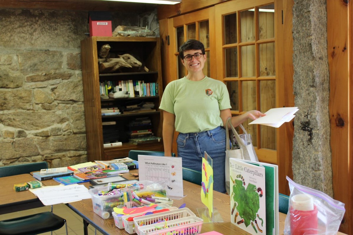 Park Intern stands behind table with children's activities available