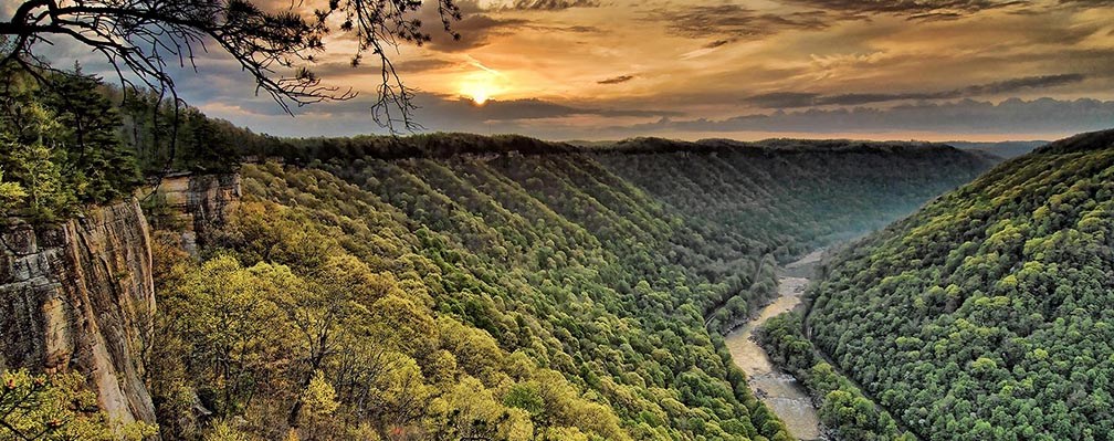 sunset over a deep forested river gorge