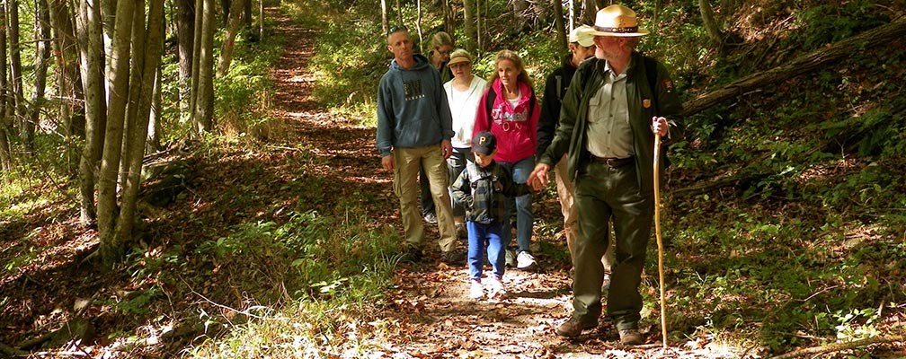 ranger leading a hike on a forested trail