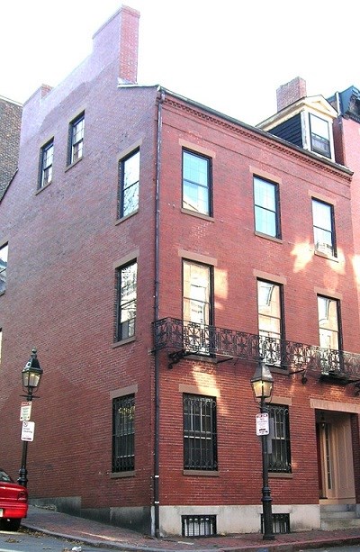 Corner view of three story brick townhouse.