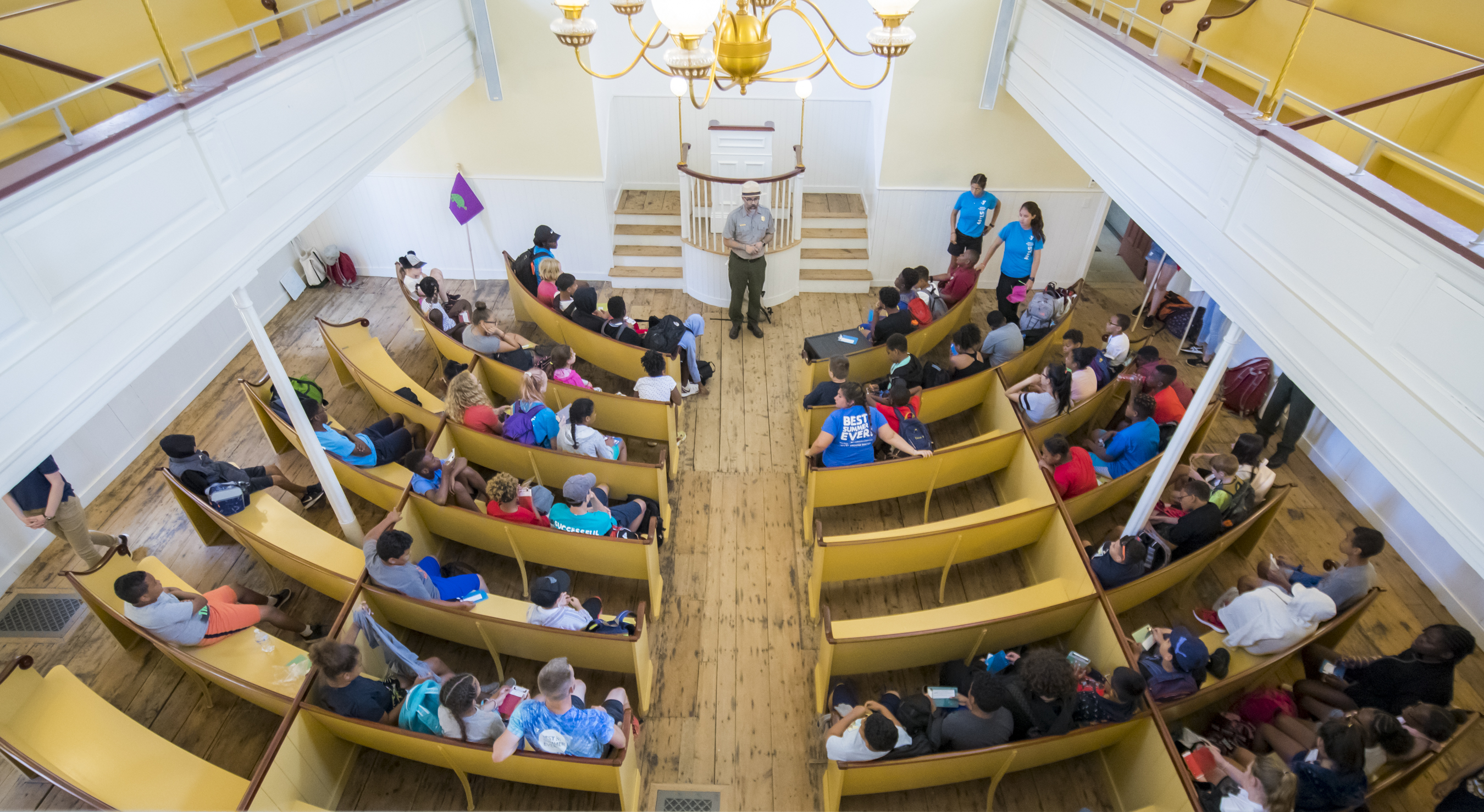 Inside the African Meeting House with a Ranger talking to students.