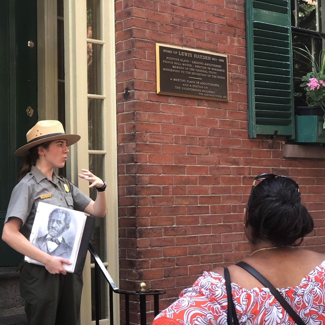 Ranger standing in front of the Lewis Hayden house explaining his relevance to visitors