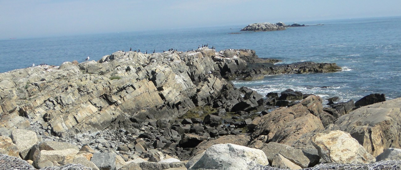 rocky outcropping sitting above blue water