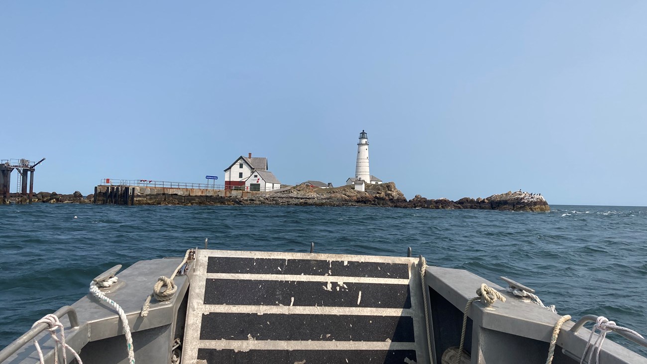 boat approaching small island with a lighthouse