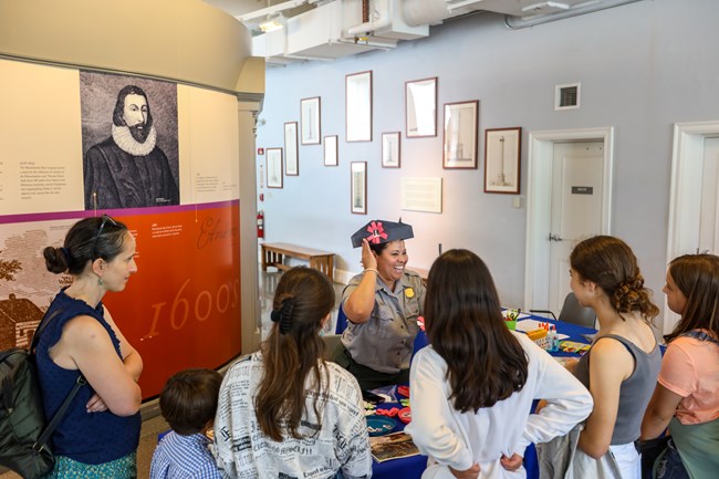 A Ranger showing an arts and crafts activity to visitors of a museum.