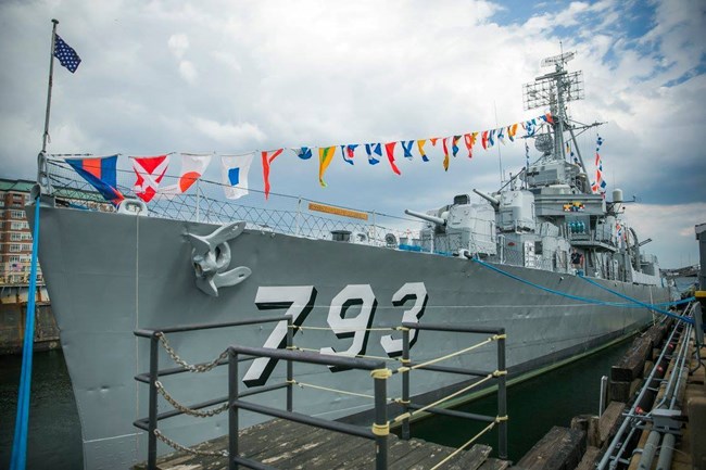 USS CASSIN YOUNG, berthed in the Charlestown Navy Yard. The USS Cassin Young, berthed in Dry Dock One at the Charlestown Navy Yard. It is a grey hulled destroyer with the numbers 7 9 3 on the hull, her identification.