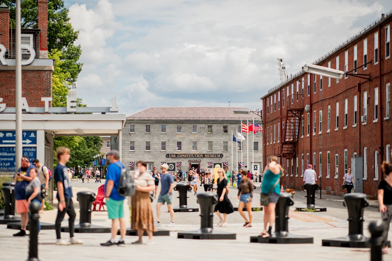 Entrance to the Charlestown Navy Yard, with Gate 1 on the left and Building 5, a long brick building, to the right.