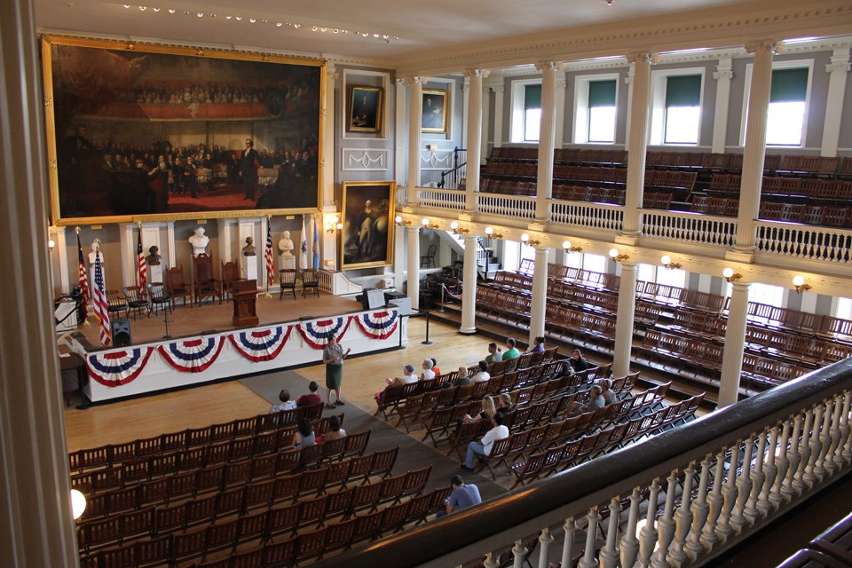 The Great Hall of Faneuil Hall The Great Hall of Faneuil Hall is an open meeting space with a gallery level. Doric and Ionic columns support the room. Portraiture and busts decorate the space.