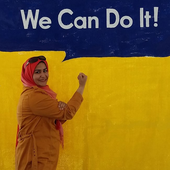 Woman flexing her right arm against a yellow background with a speech bubble reading "We Can Do It!"
