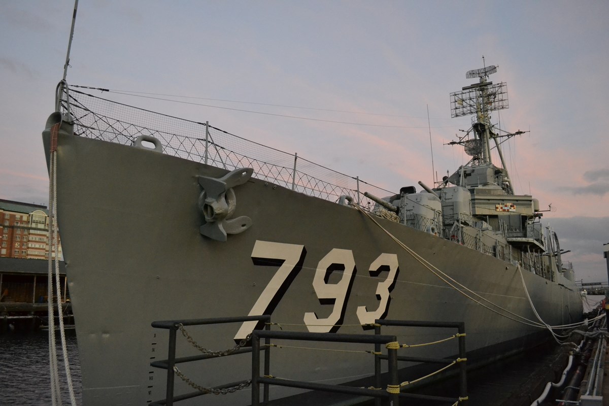 Bow of USS CASSIN YOUNG, a naval destroyer, against a partly cloudy winter sunset.