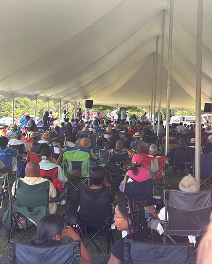 A group of seated spectators face the stage preparing to listen to a musical group.