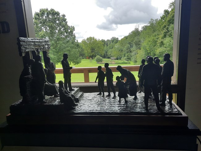 Statue of Emancipation Proclamation being read on front porch of Big House