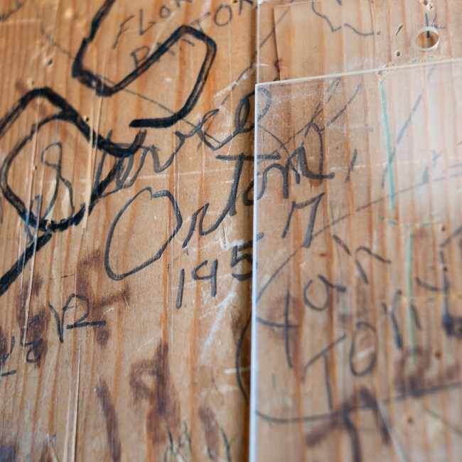 A wall of signatures including one that reads STEVE ORTON 1957