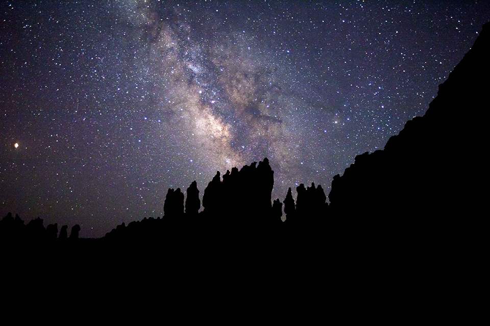The Milky Way glows above Bryce Canyon's hoodoos Night sky above dark hoodoos