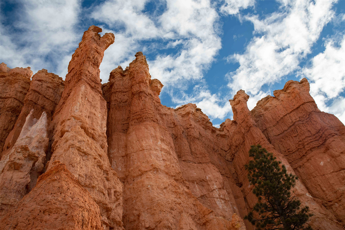 Red rocks tower before a blue clouded sky