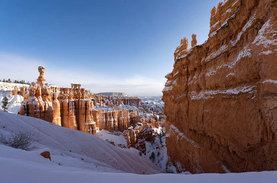 Red rock walls and spires in snowy landscape