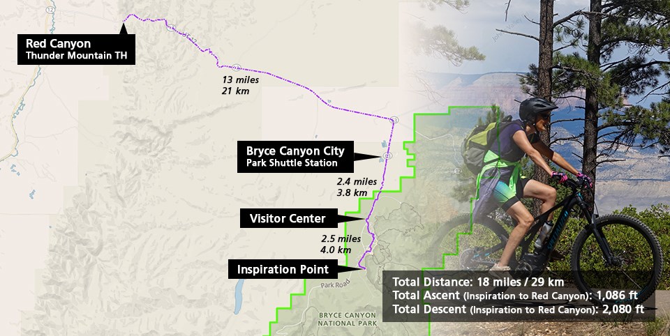 Two cyclists travel along a forested bike path with trail map