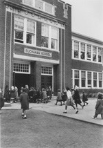 Image of students running towards the entrance of the Buchanan School, date unkown.
