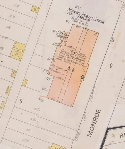 Sanborn Fire Insurance Maps depictive map of the current, two-story Monroe Elementary building. There are no cardinal directions on the map. The school building rests on a plot of land appearing to be 11 lots — 505, 507, 509, 511, 513, 515, 517, 519, 521, 523, and 525 of the Ritchies Addition— combined and labeled as 1501, 1507, 1519 and then in parenthesis (1521) and (1523) Southeast Monroe Street. While all lots were combined for the school site, the buildings right exterior wall doesnt begin until lot 511, or 1507 Southeast Monroe Street. The left exterior building wall terminates between lots 523 and 525, or (1521) Southeast Monroe Street. The two-story school building is labeled Monroe Public School and Negro in parenthesis and colored light peach. The words Heat: Steam and Lights: Elec. are below Negro. The front of the building faces to the right-hand side of the map, which is Monroe Street. The layout of the building is a rectangular block with a center hall running the length of the building and features a projecting block to the rear of the building labeled Auditorium and Gymnasium. On the back side of the building and adjacent to the Auditorium and Gymnasium extension is a small block addition labeled as Coal Pit Und Grad and Fire proof construn. While constructed with many classrooms and support rooms on both floors there are no room dimensions or floor plans provided for any interior rooms. The majority of ceiling heights in the building are 12 feet with a 25-foot ceiling height in the Auditorium and Gymnasium. Labeled in the center of the building is (Built 1926) in parenthesis and the following text: Fireproof Constrn., Walls, Concr, Flrs. & Roof Slab. False Frame Roof Above. Only portions of other lots both in front of the building across Monroe Street and behind the school building can be seen on the map, but none are complete lots or show any details. Monroe Street appears to be a standard 60-foot-wide street, although no dimensions are shown on the map.