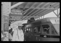 Colored waiting room sign outside of the bus station. Photo, 1940.