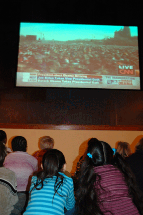 Students from a local school watch the screen as President-elect Obama arrives.