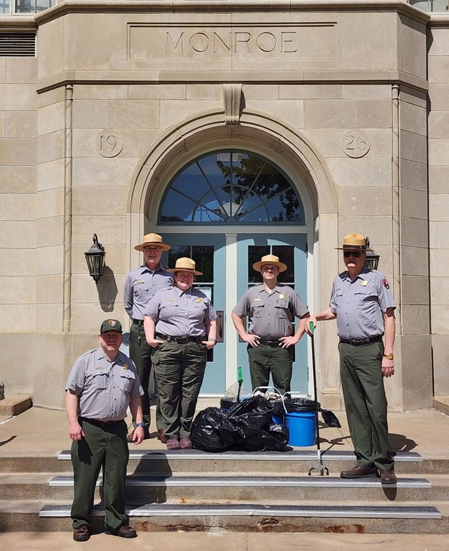 Park rangers pose in front of Monroe Elementary after cleaning up trails arounfd the park.
