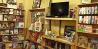 Books and videos on shelves in bookstore.