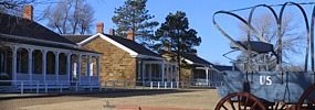 Fort Larned National Historic Site: Multiple brick buildings with columned porches. A wagon with "US" written on the side, is in the right foreground.